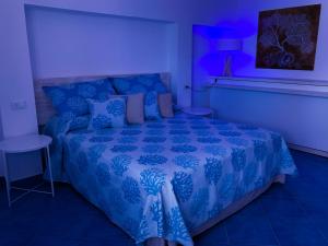 a blue bedroom with a bed with a blue comforter at Nonna Pasqualina in Panarea