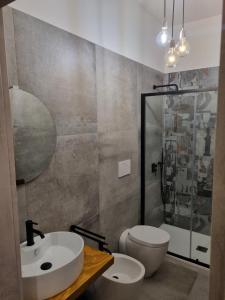 a bathroom with a sink and a toilet and a mirror at Urban Rooms Porto Cesareo in Porto Cesareo