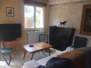 - un salon avec un canapé, une table et une télévision dans l'établissement Charmante maisonnette en duplex au pied du Château, à Nogent-le-Rotrou