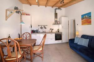 een keuken en eetkamer met een tafel en een blauwe bank bij Casa Cobra in Moncarapacho