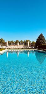 a large blue swimming pool with its reflections in the water at Occidental Aranjuez in Aranjuez