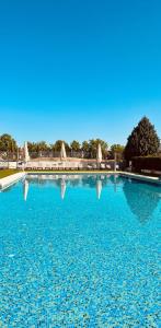 ein großer blauer Pool mit Reflexionen im Wasser in der Unterkunft Occidental Aranjuez in Aranjuez