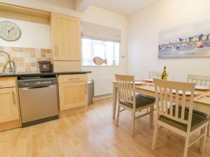 a kitchen and dining room with a table and chairs at Ocean Watch 1 in Weymouth