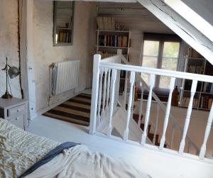 Cette chambre dispose d'un escalier avec un lit et un escalier. dans l'établissement Charmante maisonnette en duplex au pied du Château, à Nogent-le-Rotrou