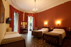 een hotelkamer met 3 bedden en een kroonluchter bij Hotel Nouvel in Barcelona
