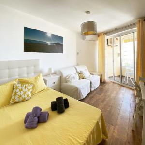 a bedroom with a yellow bed and a couch at Tamarindos Apartments by ALFRESCO STAYS in Benalmadena Costa