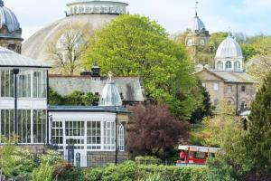 a red bus is parked in front of a building at Lovely 2 Bedroom Loft Apartment in Buxton in Buxton