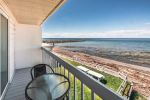 - un balcon avec une table et des chaises et la plage dans l'établissement Le Gaspesiana, à Sainte-Flavie