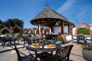 a patio with tables and chairs and a gazebo at Burrendale Hotel Country Club & Spa in Newcastle