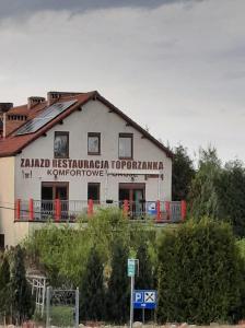 un bâtiment blanc avec un panneau sur son côté dans l'établissement Toporzanka, 