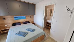 una camera da letto con un letto con due asciugamani blu sopra di Mobilhome NaMore C4, Tisno a Tisno (Stretto)
