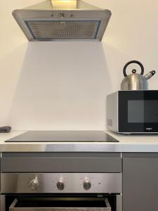 uma cozinha com um micro-ondas e um fogão forno superior em Villa des Thermes - T3 em Royat