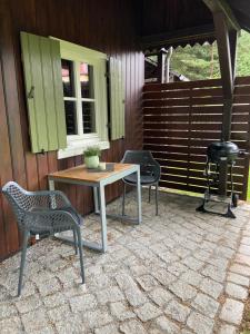 a patio with a table and chairs and a grill at Cottage am Heiderand in Dresden