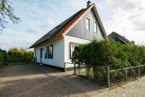 une maison blanche avec un toit en gambrel dans l'établissement Buitenplaats 100 Callantsoog, à Callantsoog