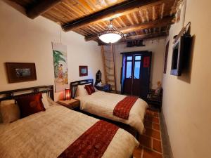 a bedroom with two beds and a television in it at Da Fu Di B&B in Jincheng