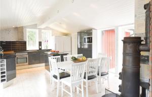 - une cuisine avec une table blanche et des chaises blanches dans l'établissement Nice Home In Lilla Edet With House A Panoramic View, à Lilla Edet