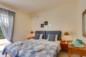 a bedroom with a bed and a table and a window at Villa Aggeliki by Villa Plus in Pírgos Psilonérou +10 photos