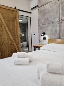 a bedroom with a large white bed with towels on it at Urban Rooms Porto Cesareo in Porto Cesareo