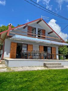 una casa con sillas y una mesa frente a ella en Mrežnica - Zelena oaza I, en Generalski Stol