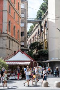 a group of people walking around a street market at Marathon Hostel in Genoa