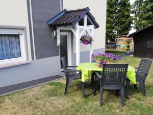 una mesa y sillas en un patio trasero con cenador en Ferienwohnung Altmaier - Ferien auf dem Lande, en Griebelschied