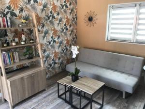 ein Wohnzimmer mit einem Sofa und einem Tisch in der Unterkunft Appartement neuf avec jardin privatif in Périgueux