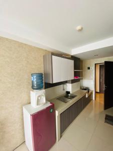 a kitchen with a small refrigerator and a sink at Hozby Skyview Setiabudi Suites in Sunggal
