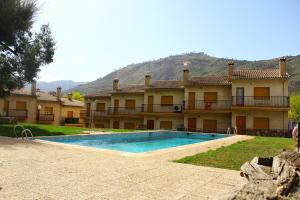 a house with a swimming pool in front of it at Residencial Los Robles in Arroyo Frio