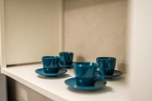 a row of blue cups and saucers on a shelf at MATE' APARTMENTS - FREE WIFI & AIR CONDITIONAL - Molfetta, Puglia, Italy in Molfetta