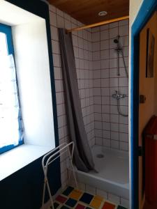 a bathroom with a tub and a shower with a window at Les Hortensias GR 34 - Chambres d'Hôtes in Trévou-Tréguignec +50 photos