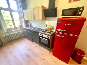 a red refrigerator in a kitchen with a stove at Gästehaus Sternschanze - App 3 Bootsmann in Stralsund