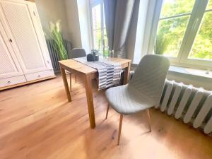a table and chair in a room with a window at Gästehaus Sternschanze - App 3 Bootsmann in Stralsund