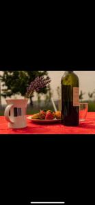 a bottle of wine and a plate of fruit on a table at la baita nei boschi in Serramazzoni