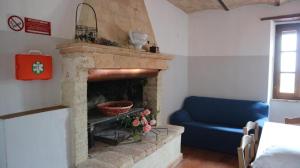 a living room with a brick fireplace with a blue couch at Agriturismo Portoreschi in Saragano