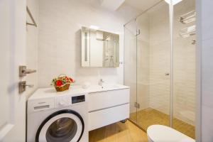 a bathroom with a washing machine and a shower at Pink Sahara near City Center in Oradea