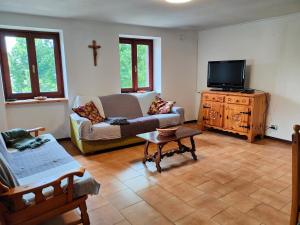 a living room with a couch and a tv at Appartamento Chatrian 1 CIR-TORGNON-0030 in Torgnon