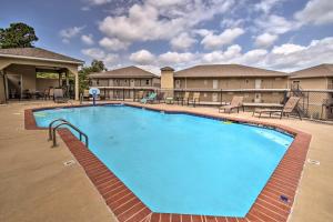 een groot zwembad in een hotel met tafels en stoelen bij Hot Springs Condo on Lake Hamilton with Pool Access in Hot Springs
