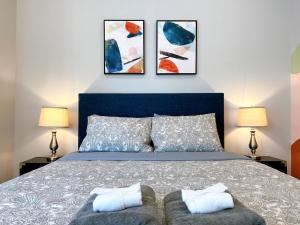 a bedroom with a blue bed with two lamps at Stay at Luna on Ridge Ave in Philadelphia