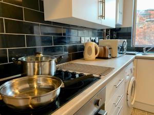 a kitchen with pots and pans on the stove at Lovely 1 bedroom, 4 guests service apartment in Doncaster