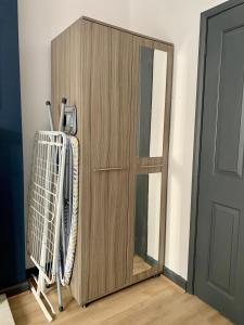 um armário de madeira com raquetes de ténis ao lado de uma porta em Lovely 1 bedroom, 4 guests service apartment em Doncaster