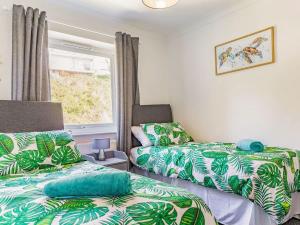 a room with two beds and a window at Lovely Magnolia Apartment 6 single beds in Torquay