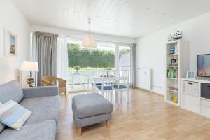 uma sala de estar com um sofá e uma mesa em Wittdün 2 em Scharbeutz