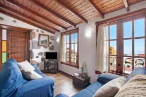 ein Wohnzimmer mit einem blauen Sofa und Fenstern in der Unterkunft Casa Pedro in Icod de los Vinos