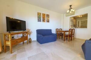 sala de estar con sofá azul y TV en CT 184 - Atalaya del Sol, en Mijas Costa