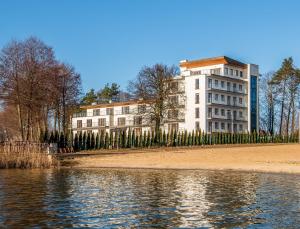 un gran edificio junto a una masa de agua en Rezydencja Margonin en Margonin