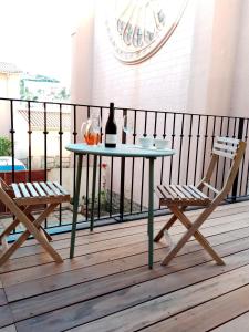 una mesa con una botella de vino y 2 sillas en el balcón en La Villa Rosace en Cerbère