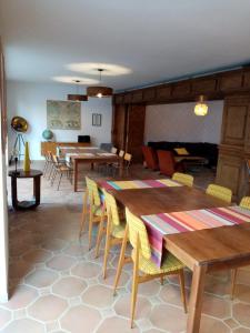 a room with wooden tables and chairs and a couch at La Villa Rosace in Cerbère