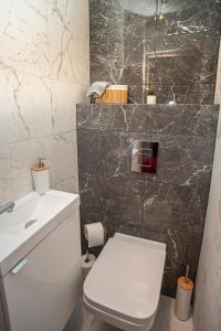 a bathroom with a white toilet and a sink at Apartament Panorama in Warsaw +36 photos