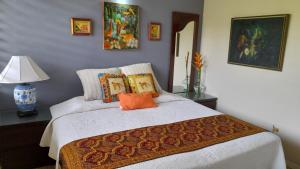 a bedroom with a white bed with an orange pillow at Neita's Nest in Kingston