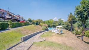 un parque con un banco en el césped en La Casa sulla Collina - Italian Homing, en Padenghe sul Garda